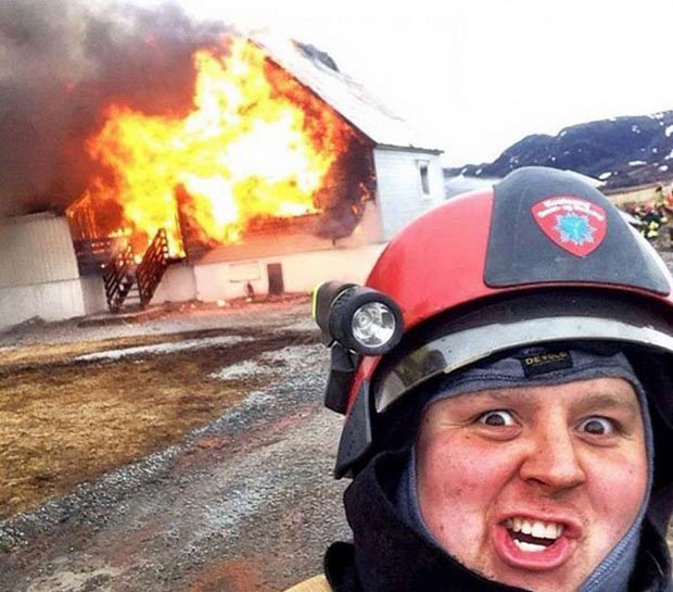 Funny fireman photobomb in front of burning house. 